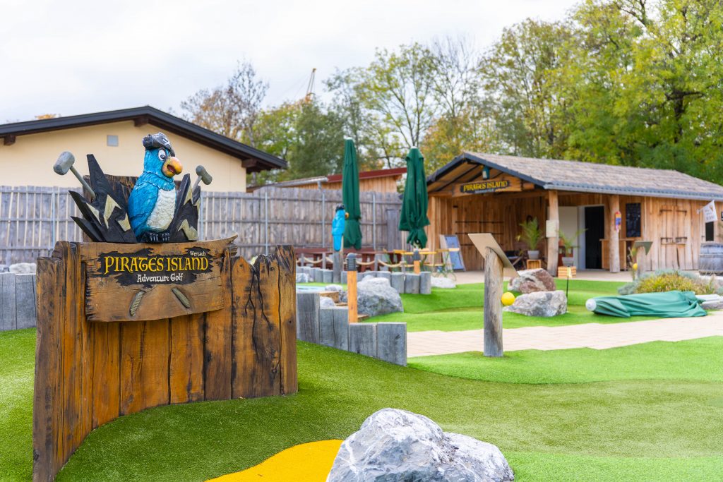 Blick auf Minigolfplatz mit Hütte und Sitzplätzen