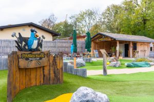 Blick auf Minigolfplatz mit Hütte und Sitzplätzen